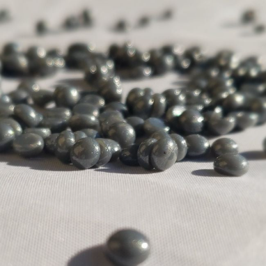 Simpli Zen grey wax beads spilled out on a white background
